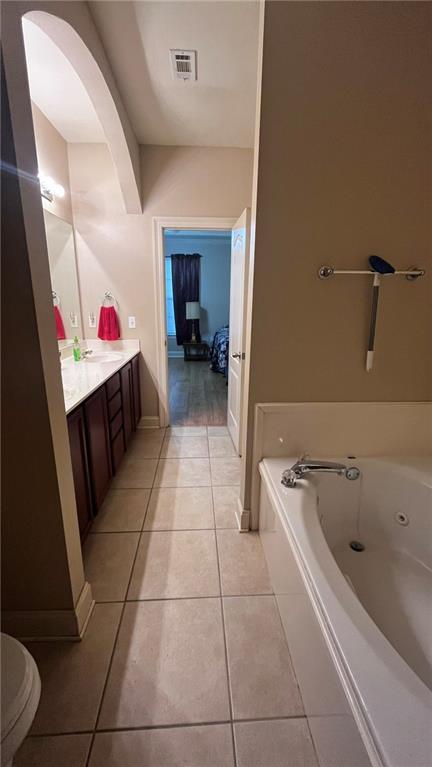 40145 Taylors Trl Unit 304, Slidell, LA 70461 - bathroom with vanity, a whirlpool tub, and tile patterned flooring
