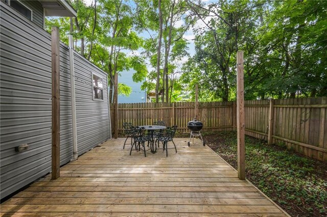 3606 N Miro St, New Orleans, LA 70117 - wooden deck with outdoor dining space, a fenced backyard, and a grill