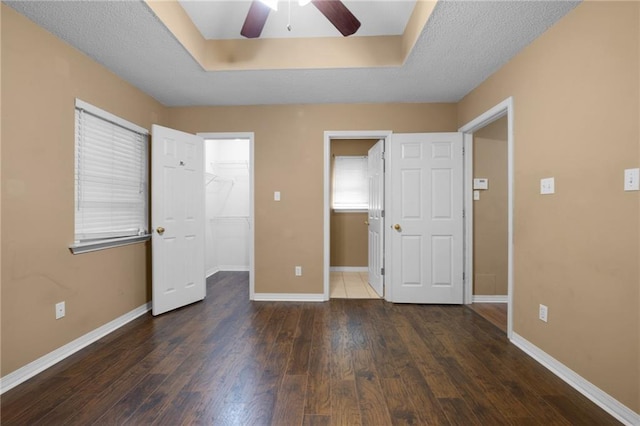 70405 F St, Covington, LA 70433 - unfurnished bedroom with wood finished floors, a walk in closet, a closet, and a ceiling fan