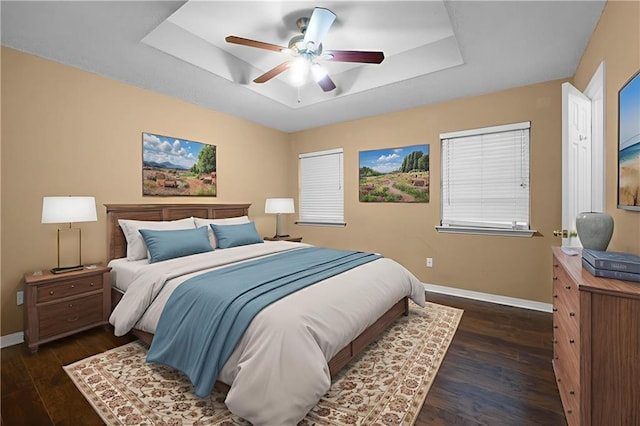 70405 F St, Covington, LA 70433 - bedroom featuring a tray ceiling, dark wood-style floors, and ceiling fan
