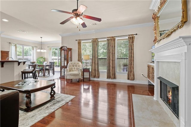 855 Woodsprings Ct, Covington, LA 70433 - living area featuring a fireplace with flush hearth, ceiling fan, light wood-style floors, ornamental molding, and a chandelier
