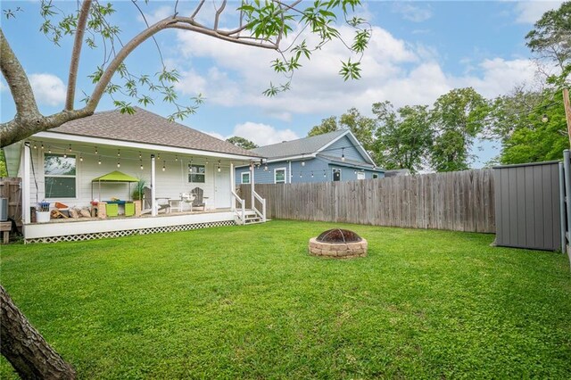 1112 Compromise St, Kenner, LA 70062 - rear view of property featuring an outdoor fire pit, a fenced backyard, a wooden deck, and a shingled roof