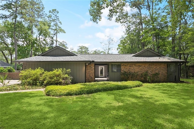 285 Oak Dr, Mandeville, LA 70471 - view of front of home featuring a front lawn, brick siding, and a shingled roof
