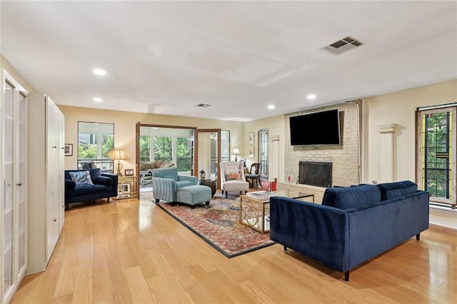 285 Oak Dr, Mandeville, LA 70471 - living area featuring light wood-style flooring, a large fireplace, recessed lighting, and french doors