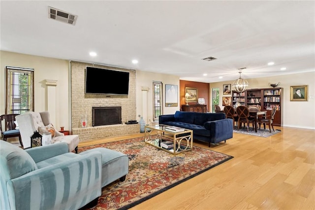 285 Oak Dr, Mandeville, LA 70471 - living area with light wood-style flooring, a chandelier, recessed lighting, and a fireplace