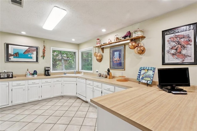 285 Oak Dr, Mandeville, LA 70471 - kitchen featuring white dishwasher, white cabinets, a textured ceiling, light countertops, and light tile patterned floors