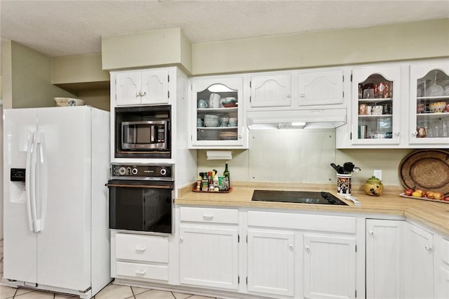 285 Oak Dr, Mandeville, LA 70471 - kitchen with black appliances, range hood, light countertops, white cabinetry, and a textured ceiling
