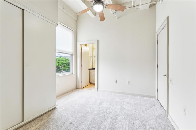 835 Julia St Unit 8, New Orleans, LA 70113 - unfurnished bedroom with light colored carpet, ensuite bathroom, beam ceiling, ceiling fan, and a towering ceiling