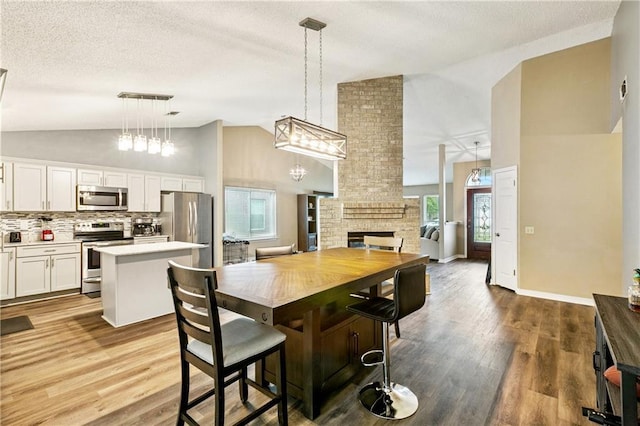 310 Oakley Ln, Destrehan, LA 70047 - kitchen with stainless steel appliances, a center island, light countertops, dark wood finished floors, and a textured ceiling