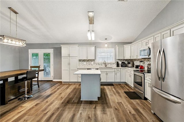 310 Oakley Ln, Destrehan, LA 70047 - kitchen featuring appliances with stainless steel finishes, light countertops, decorative backsplash, a textured ceiling, and decorative light fixtures