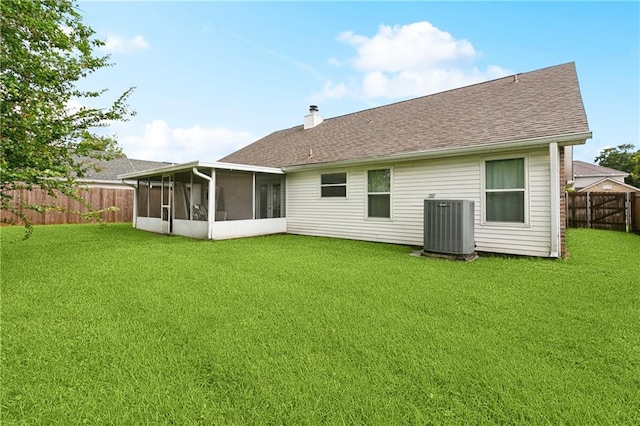 310 Oakley Ln, Destrehan, LA 70047 - back of property featuring a sunroom, a fenced backyard, a chimney, and a shingled roof