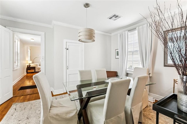 917 Joliet St, New Orleans, LA 70118 - dining area with wood finished floors, crown molding, and plenty of natural light