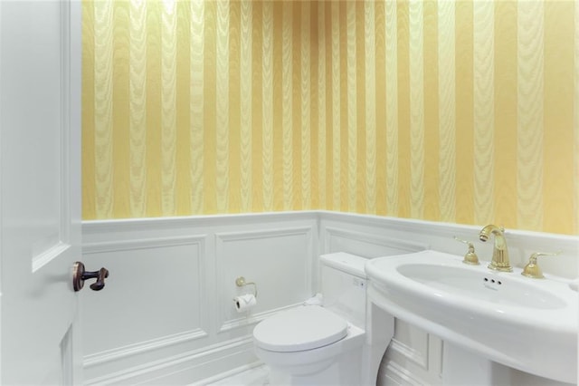 625 St Charles Ave Phd, Phd, New Orleans, LA 70130 - bathroom with wallpapered walls, wainscoting, and a decorative wall