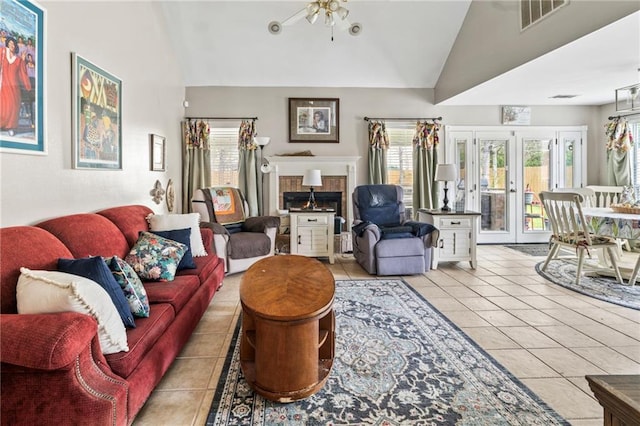 19199 Hector St, Mandeville, LA 70471 - living area with light tile patterned floors, high vaulted ceiling, a fireplace, french doors, and a ceiling fan