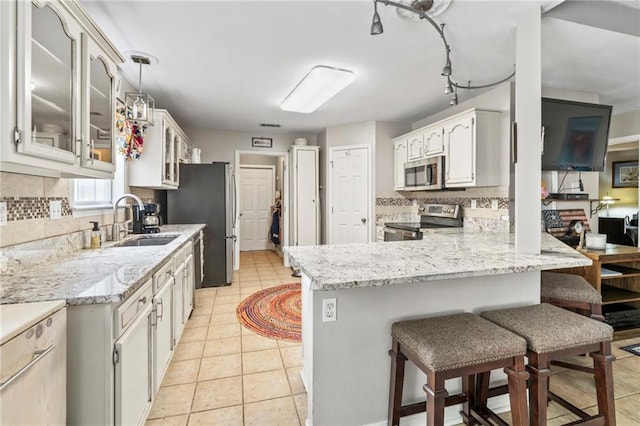 19199 Hector St, Mandeville, LA 70471 - kitchen with stainless steel appliances, tasteful backsplash, glass insert cabinets, and a peninsula