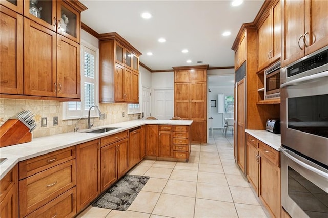 5018 St Charles Ave, New Orleans, LA 70115 - kitchen with stainless steel appliances, ornamental molding, tasteful backsplash, brown cabinetry, and recessed lighting