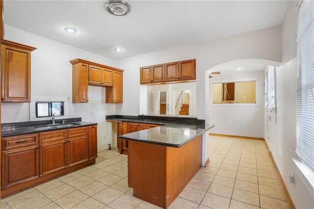 4124 Eve St, New Orleans, LA 70125 - kitchen featuring arched walkways, dark countertops, light tile patterned floors, and recessed lighting