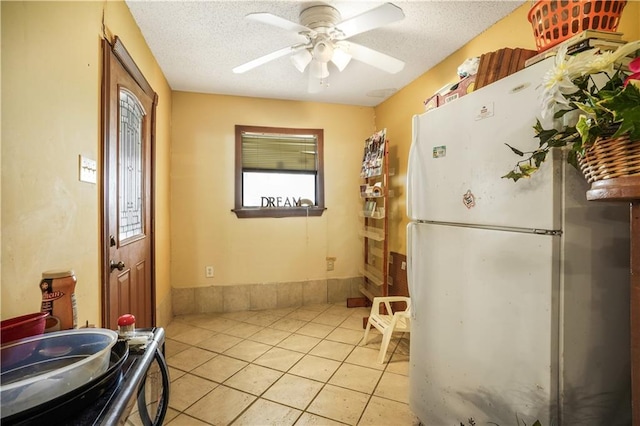 4124 Eve St, New Orleans, LA 70125 - kitchen featuring freestanding refrigerator, a ceiling fan, light tile patterned flooring, and a textured ceiling
