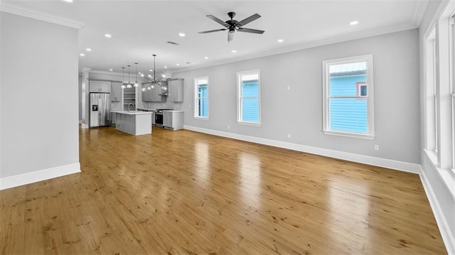 1908 Benjamin St, Arabi, LA 70032 - unfurnished living room featuring crown molding, recessed lighting, a chandelier, light wood finished floors, and ceiling fan