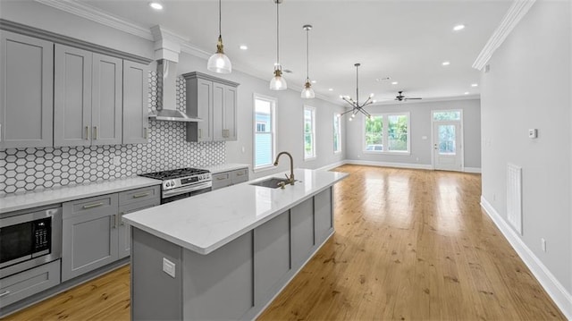 1908 Benjamin St, Arabi, LA 70032 - kitchen with gray cabinetry, appliances with stainless steel finishes, wall chimney exhaust hood, tasteful backsplash, and recessed lighting