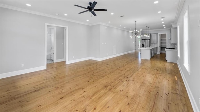 1908 Benjamin St, Arabi, LA 70032 - unfurnished living room featuring recessed lighting, ceiling fan, crown molding, light wood finished floors, and a chandelier