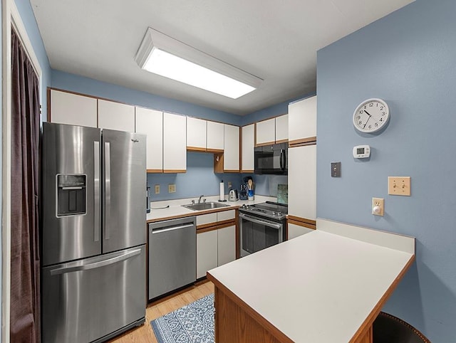 420 Metairie Hammond Hwy Unit 225, Metairie, LA 70005 - kitchen featuring stainless steel appliances, a peninsula, light countertops, light wood finished floors, and white cabinetry