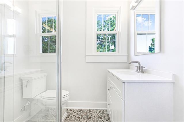 694244 Canal Blvd, New Orleans, LA 70115 - full bathroom with vanity, tile patterned flooring, and a shower with shower door
