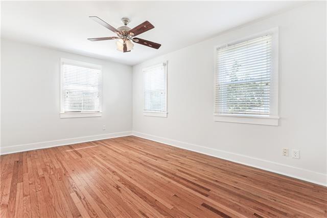 694244 Canal Blvd, New Orleans, LA 70115 - spare room with healthy amount of natural light, light wood-style floors, and a ceiling fan