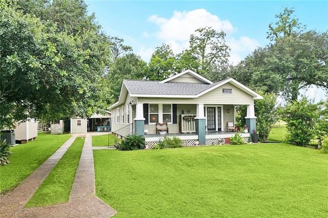 106 Rowley Blvd, La Place, LA 70068 - bungalow with covered porch, a front yard, driveway, roof with shingles, and a storage unit