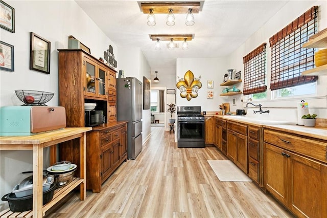 106 Rowley Blvd, La Place, LA 70068 - kitchen featuring stainless steel appliances, open shelves, light wood-style floors, and brown cabinets