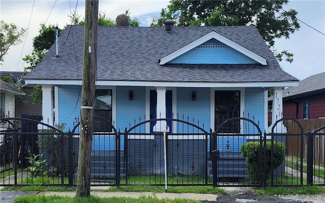 1721 Eagle St, New Orleans, LA 70118 - view of front facade featuring a porch, roof with shingles, a fenced front yard, and a gate