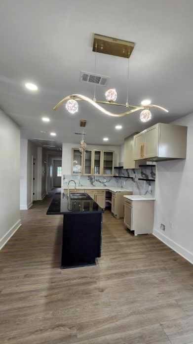 1721 Eagle St, New Orleans, LA 70118 - kitchen with glass insert cabinets, hanging light fixtures, recessed lighting, and wood finished floors