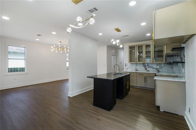 1721 Eagle St, New Orleans, LA 70118 - kitchen with a chandelier, a kitchen island with sink, dark wood-type flooring, tasteful backsplash, and recessed lighting