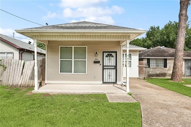 921 Jourdan Ave, New Orleans, LA 70117 - shotgun-style home with a shingled roof and covered porch