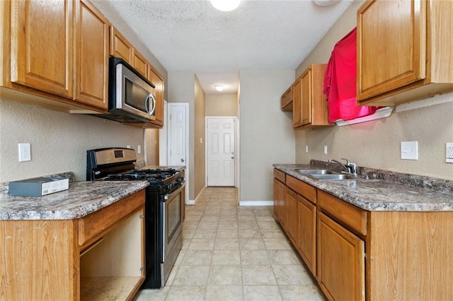 921 Jourdan Ave, New Orleans, LA 70117 - kitchen with stainless steel appliances, a textured ceiling, and brown cabinets