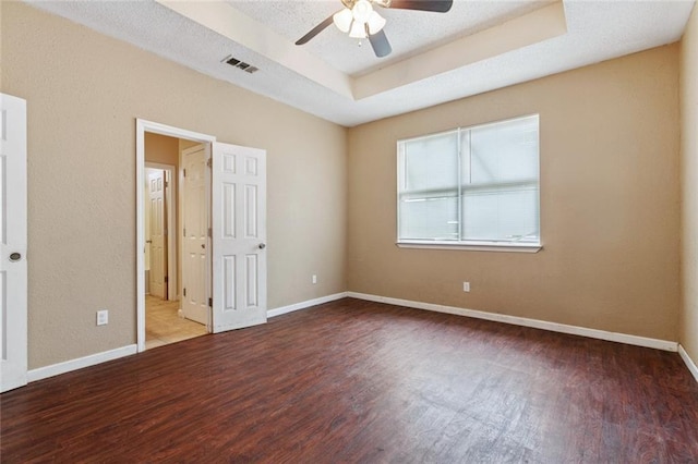 921 Jourdan Ave, New Orleans, LA 70117 - unfurnished bedroom featuring wood finished floors, a tray ceiling, and a ceiling fan