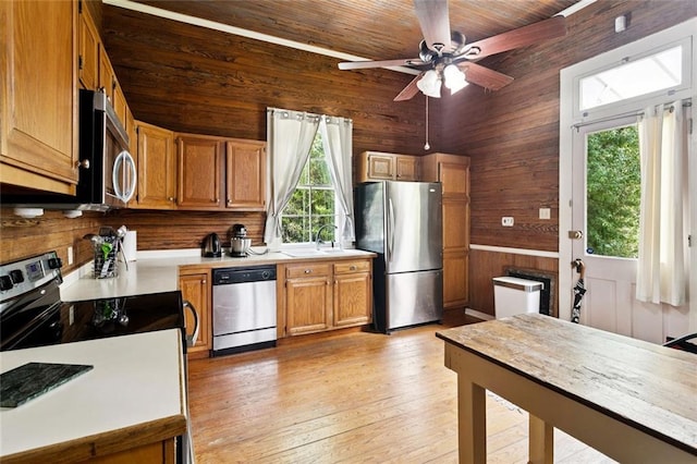 2027 Monroe St, Mandeville, LA 70448 - kitchen featuring appliances with stainless steel finishes, wooden walls, plenty of natural light, light countertops, and ceiling fan