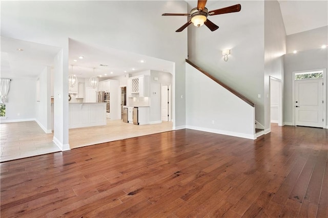 35 Elmwood Loop, Madisonville, LA 70447 - unfurnished living room with ceiling fan, light wood-type flooring, stairway, a towering ceiling, and recessed lighting