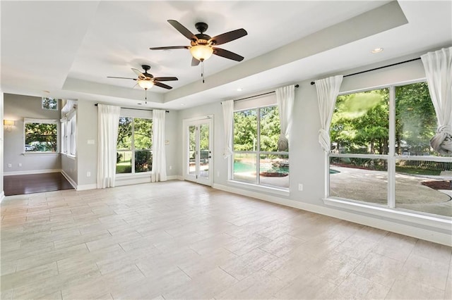 35 Elmwood Loop, Madisonville, LA 70447 - unfurnished living room featuring a tray ceiling, a ceiling fan, plenty of natural light, and recessed lighting