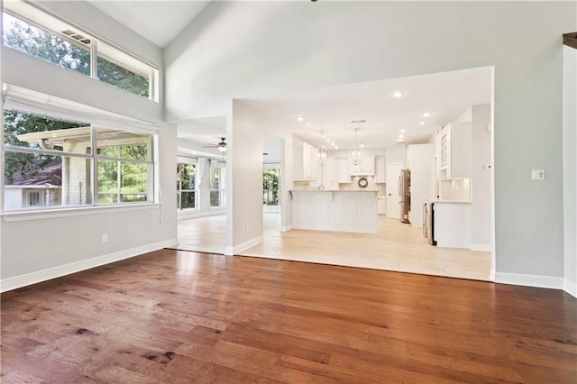 35 Elmwood Loop, Madisonville, LA 70447 - unfurnished living room with light wood-type flooring, ceiling fan, healthy amount of natural light, a high ceiling, and recessed lighting