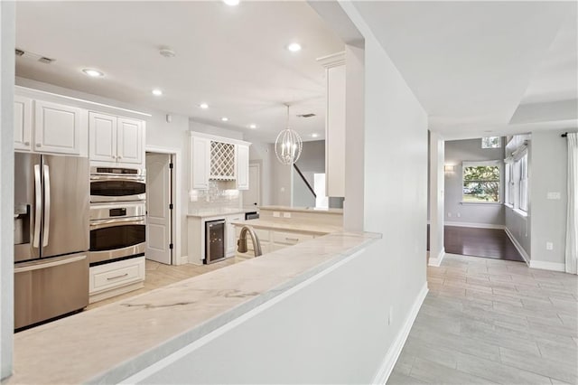 35 Elmwood Loop, Madisonville, LA 70447 - kitchen with appliances with stainless steel finishes, wine cooler, tasteful backsplash, white cabinets, and recessed lighting