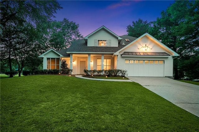 35 Elmwood Loop, Madisonville, LA 70447 - traditional-style home featuring an attached garage, concrete driveway, a lawn, a standing seam roof, and roof with shingles