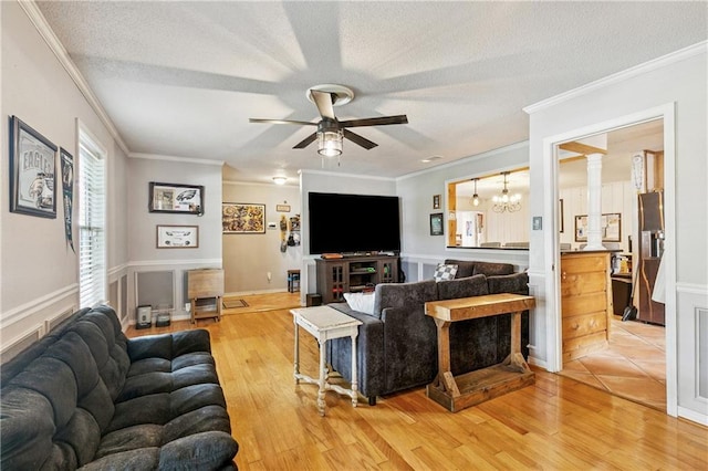 2041 Glencove Ln, Terrytown, LA 70056 - living area with ceiling fan, ornamental molding, a textured ceiling, light wood finished floors, and decorative columns
