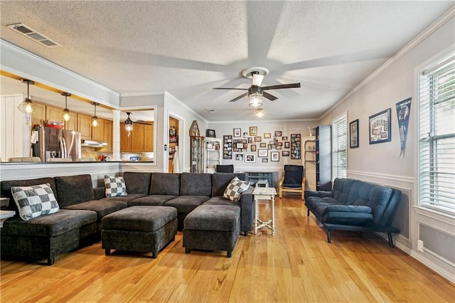 2041 Glencove Ln, Terrytown, LA 70056 - living room featuring ceiling fan, light wood-type flooring, a textured ceiling, and crown molding