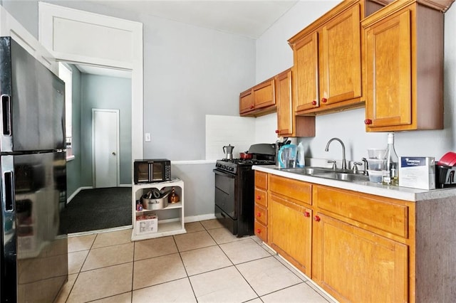 222325 Felicity St, New Orleans, LA 70113 - kitchen with black appliances, light countertops, light tile patterned flooring, and brown cabinets
