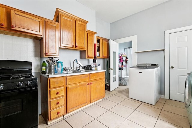 222325 Felicity St, New Orleans, LA 70113 - kitchen featuring washer / clothes dryer, black gas range, backsplash, light tile patterned floors, and light countertops