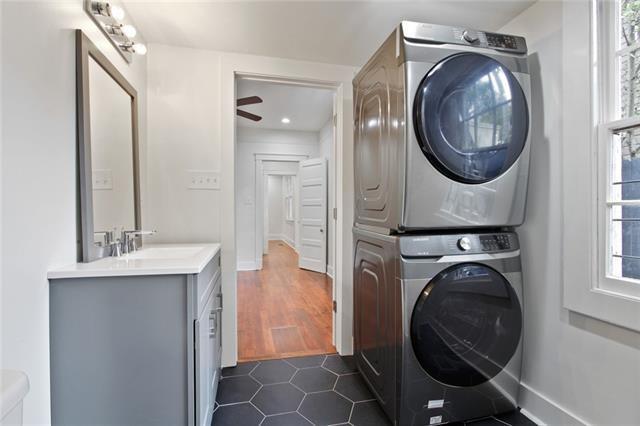 5227-29 Coliseum St, New Orleans, LA 70115 - washroom featuring estacked washer and dryer and dark tile patterned floors