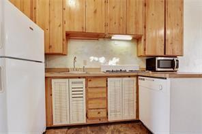 5227-29 Coliseum St, New Orleans, LA 70115 - kitchen with white appliances, light brown cabinetry, and light countertops