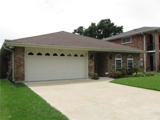 4908 Wills St, Metairie, LA 70006 - view of front of property with an attached garage, driveway, brick siding, and a front yard