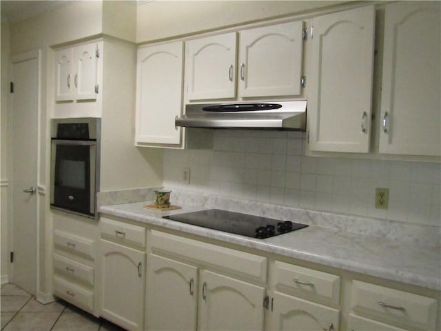 4908 Wills St, Metairie, LA 70006 - kitchen featuring oven, under cabinet range hood, black electric stovetop, and light countertops